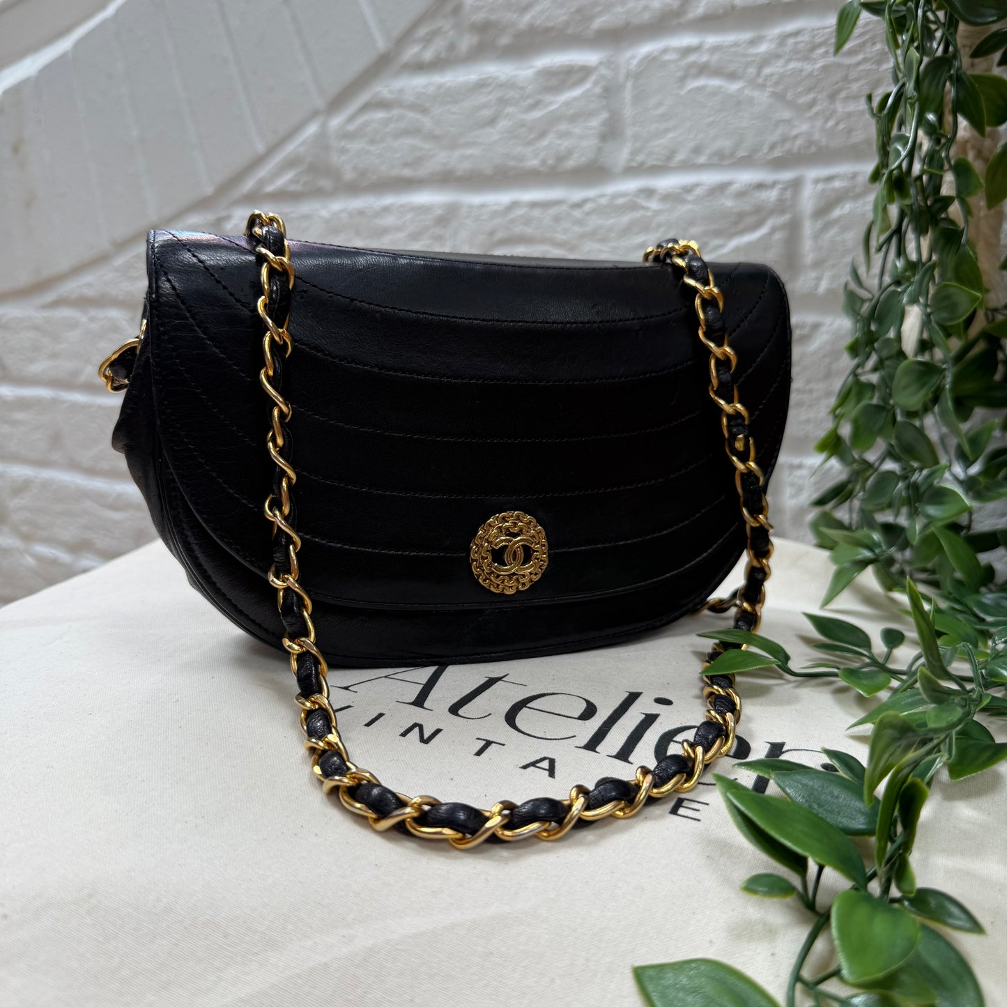Chanel Early 1980s black half moon quilted CC button flap